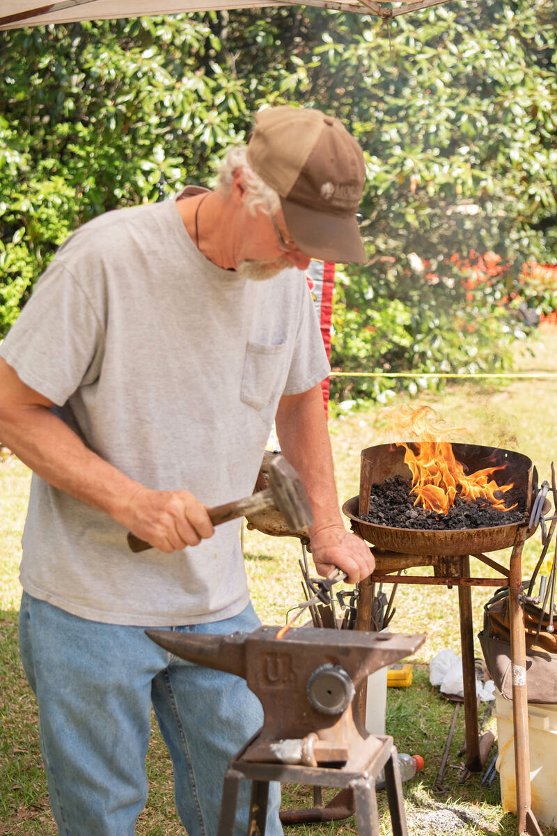 A blacksmith hammering hot iron at an anvil