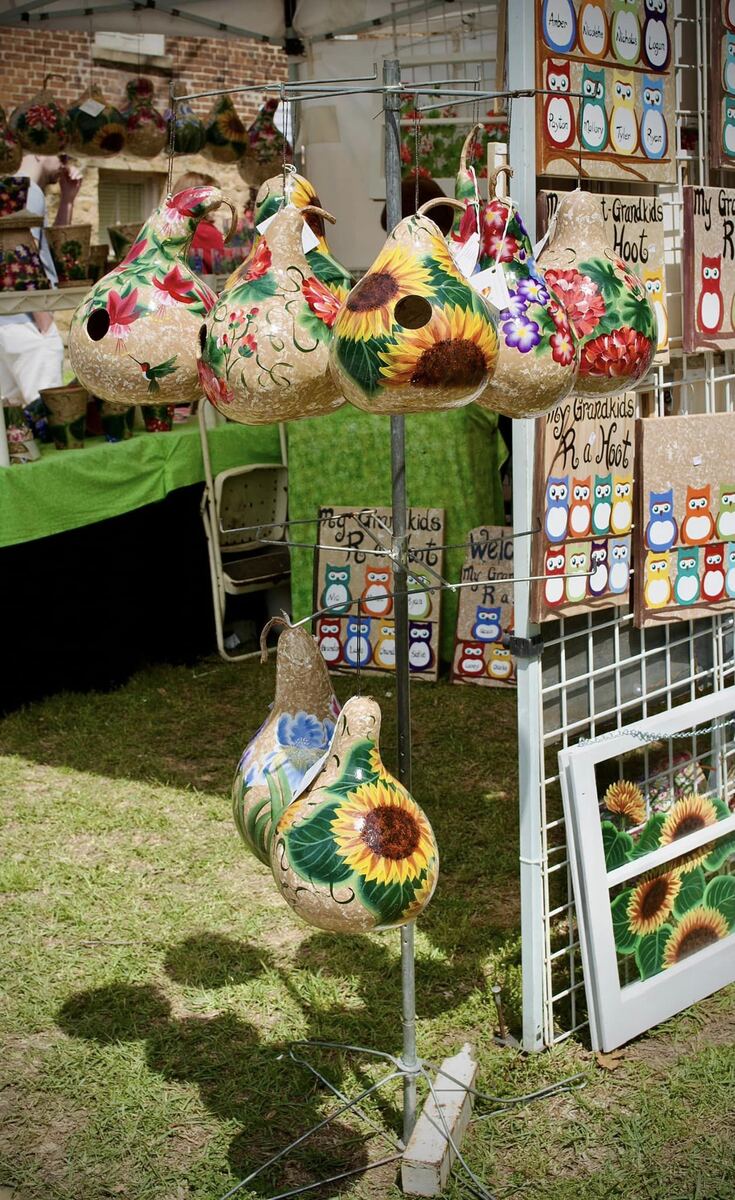 Painted gourds and floral art displayed outdoors