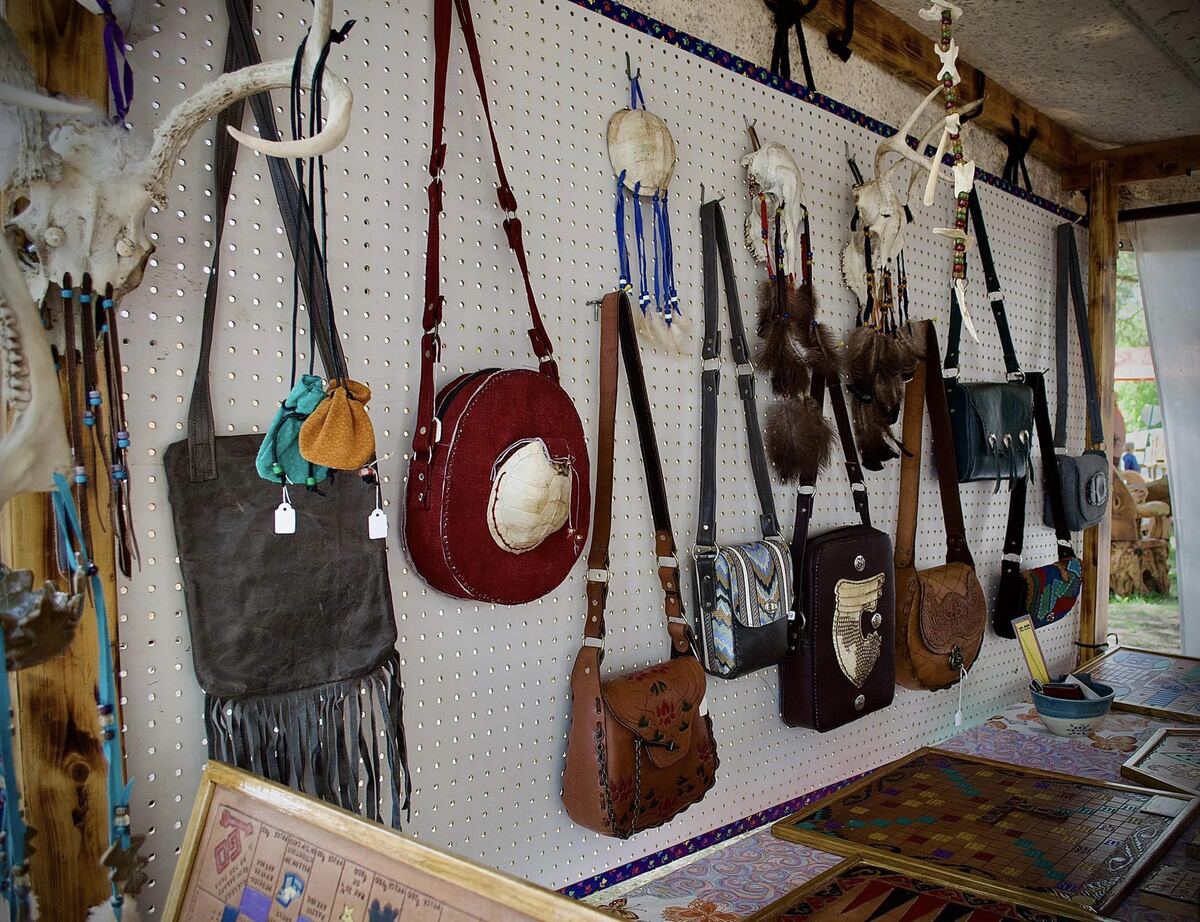 Handmade leather bags on a pegboard wall